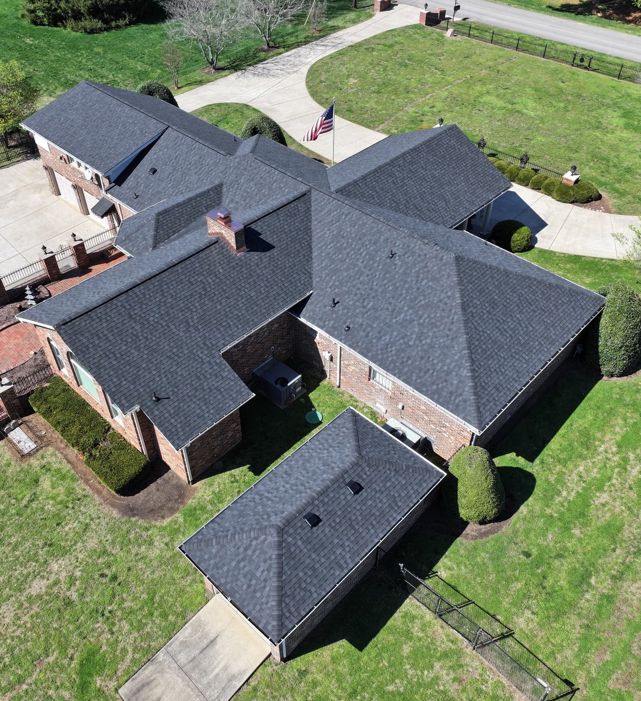 A modern home with a well-maintained asphalt shingle roof, featuring clean lines, proper gutter systems, and contrasting trim.