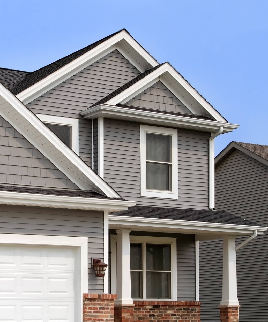 A well-maintained residential home featuring a professionally installed asphalt shingle roof with clean lines and proper gutter systems.