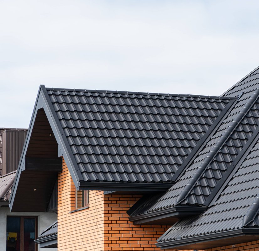 A modern house with a professionally installed, dark metal tile roof.