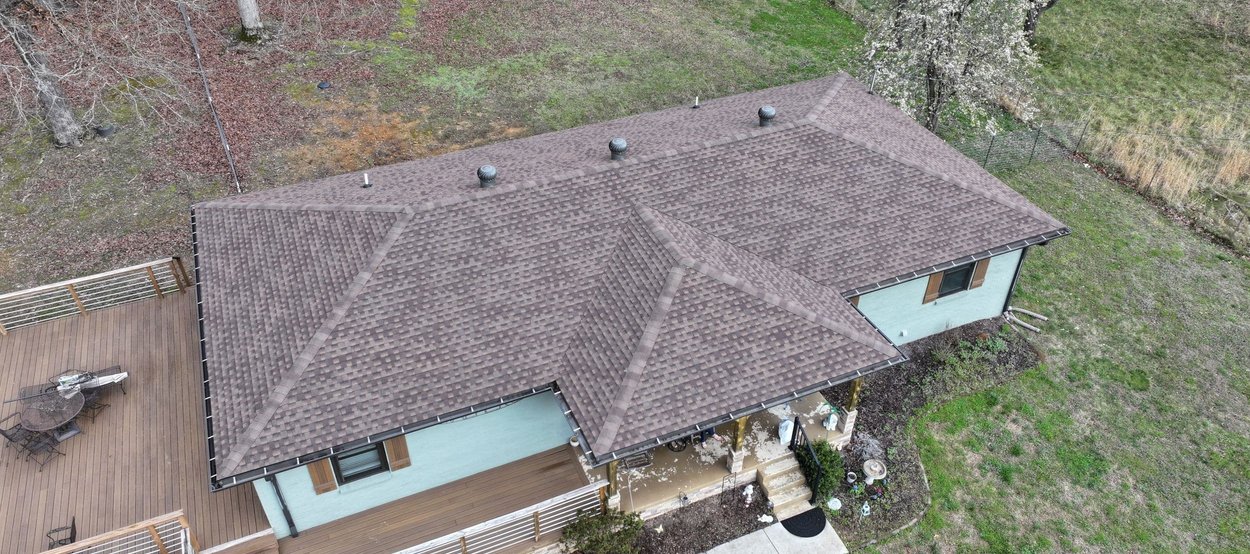 A modern house with a professionally installed, dark metal tile roof.