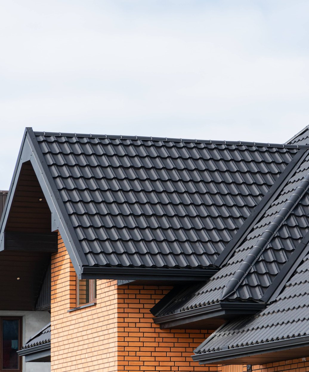 A modern home with a professionally installed dark metal tile roof showcasing clean lines and durable construction.
