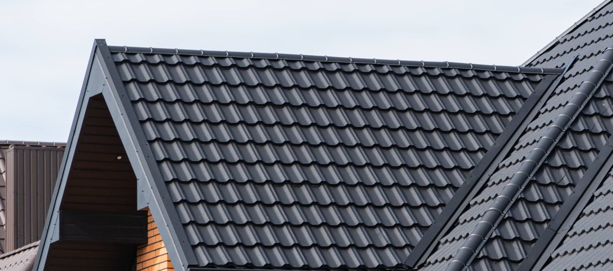 A modern house with a professionally installed, dark metal tile roof.