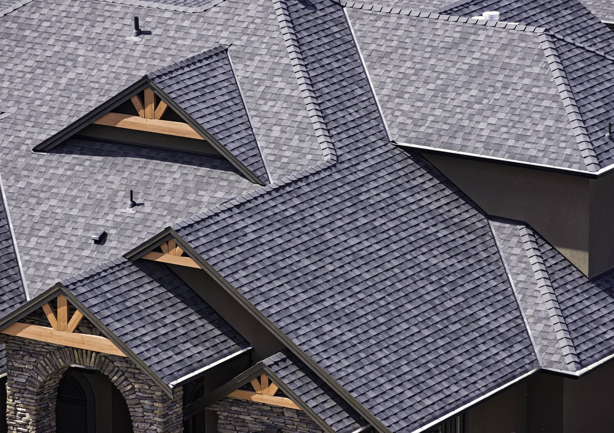 A complex roof design with multiple gables, valleys, and dormers, all covered in high-quality asphalt shingles
