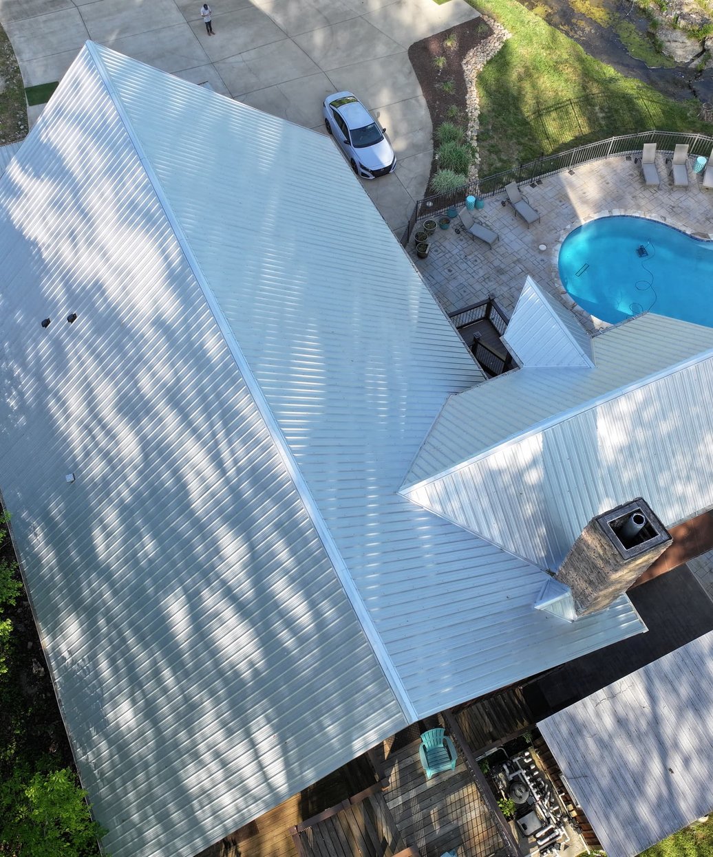 A close-up view of professionally installed seamless aluminum gutters on a residential home with clean fascia and downspout connections.