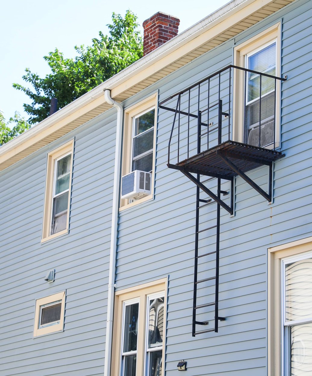 A multi-story building with professionally installed siding and a visible chimney showcasing quality exterior craftsmanship.